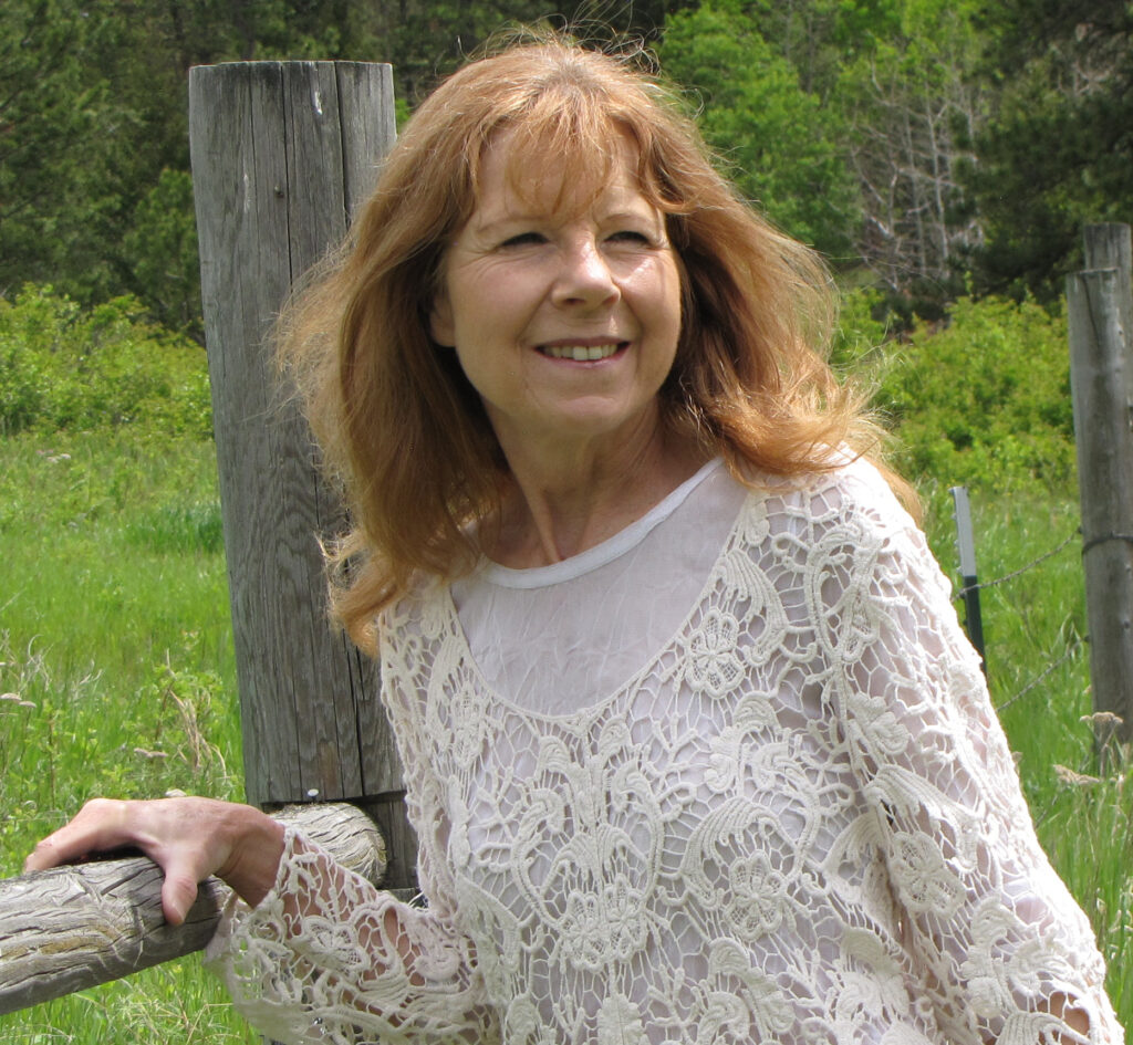 A woman in white shirt standing next to wooden pole.