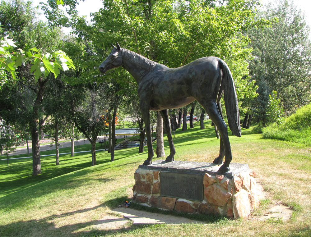 A statue of a horse standing on top of a rock.