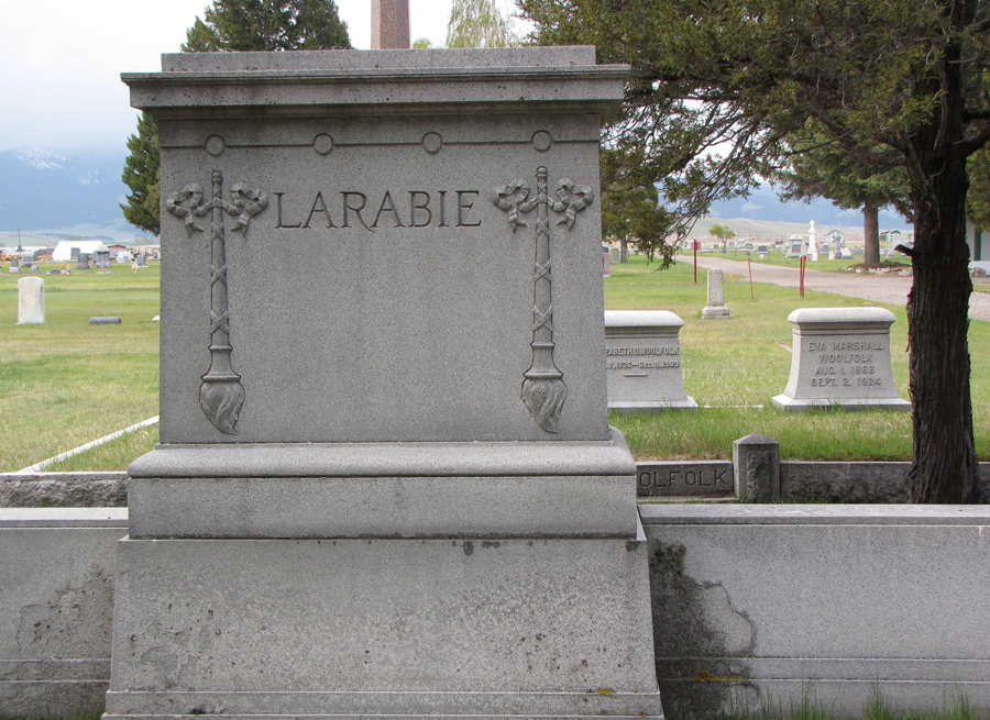 A grave in the cemetery with two benches.