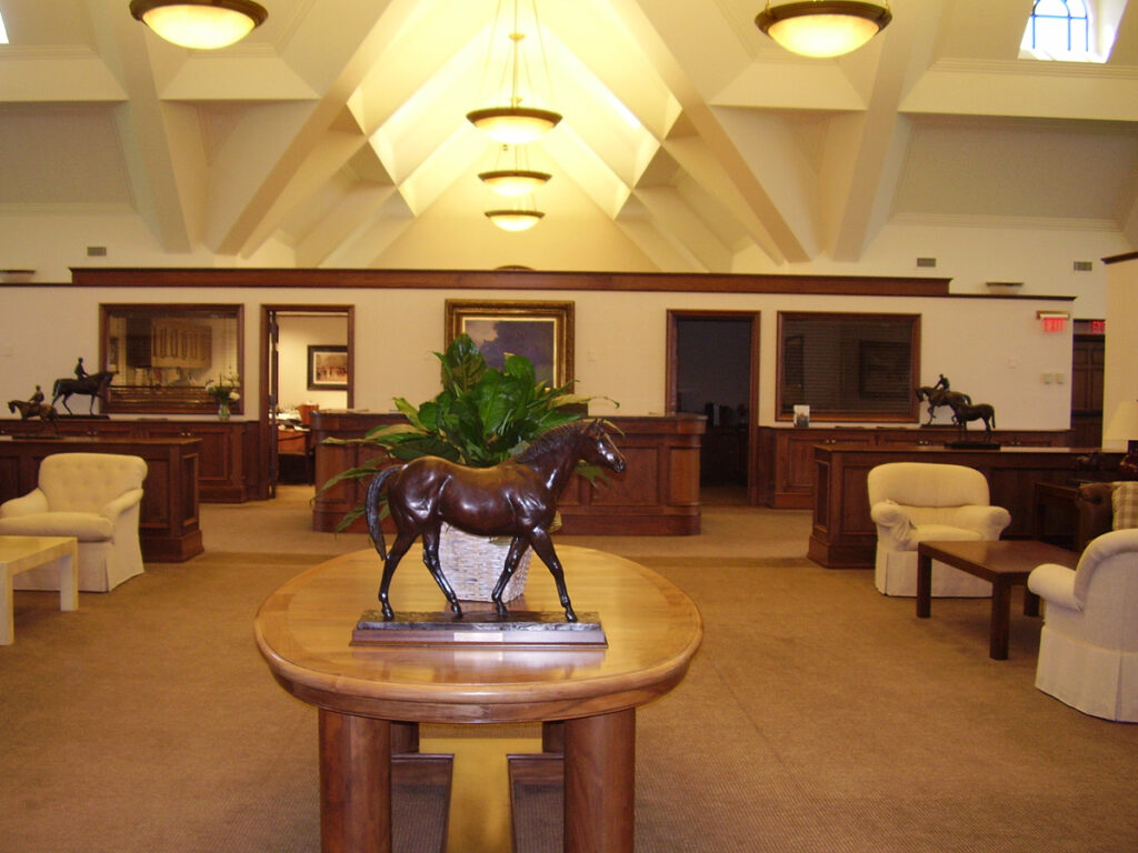 A room with a table and chairs, a horse statue on the table.